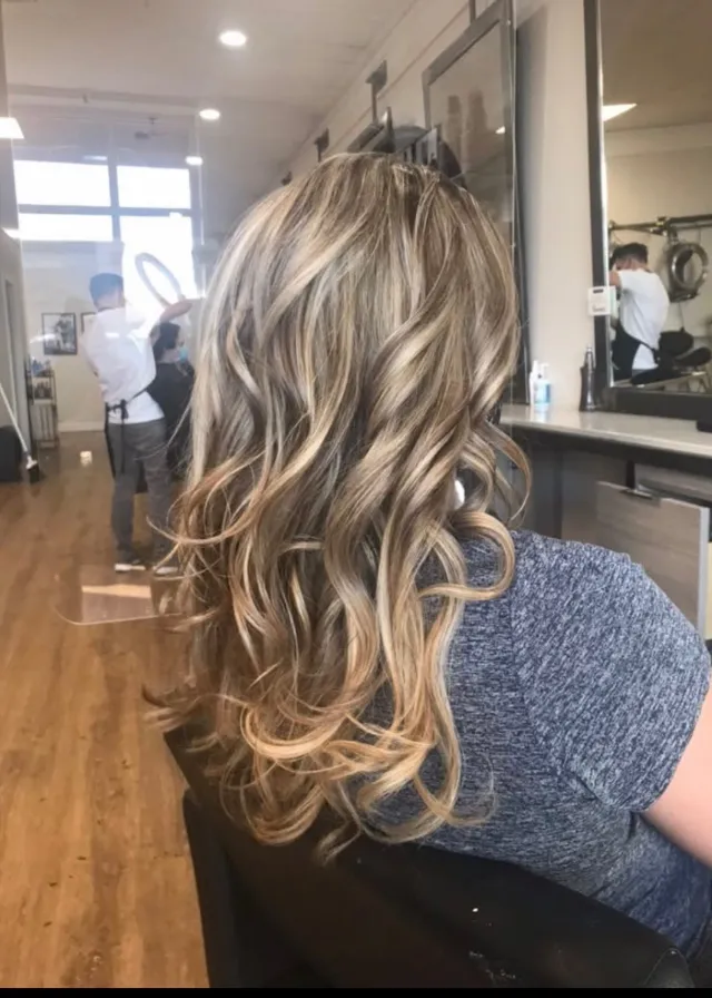 Long blonde highlights with soft layered curls.