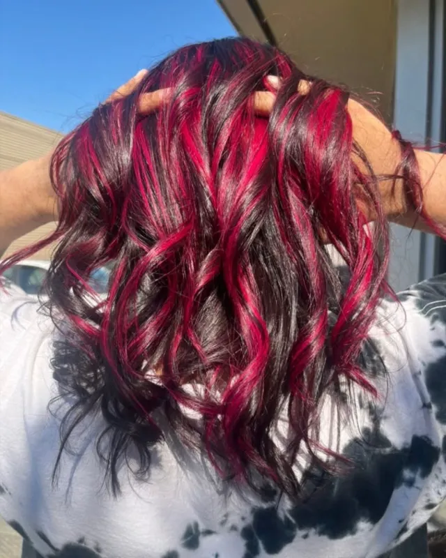 Black base hair with dimensional magenta and red ribbons in curls.