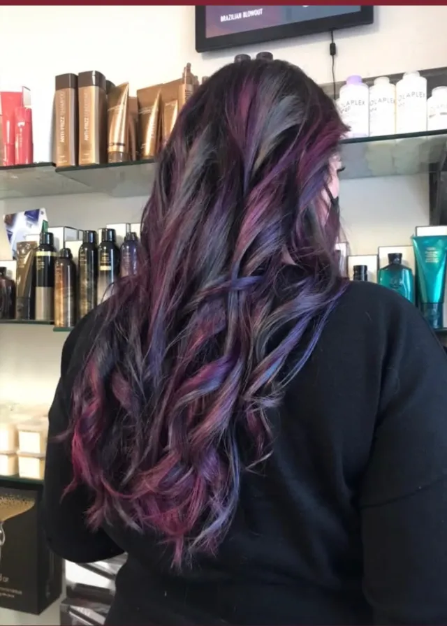 Dark hair with purple, plum, and blue dimensional color ribbons.