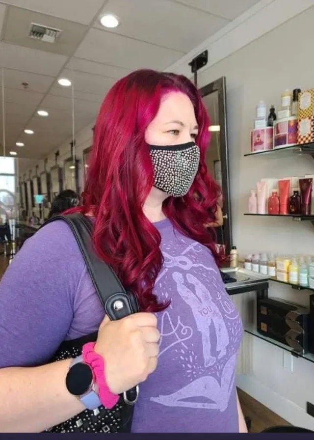 Rich red and magenta hair color styled in waves.